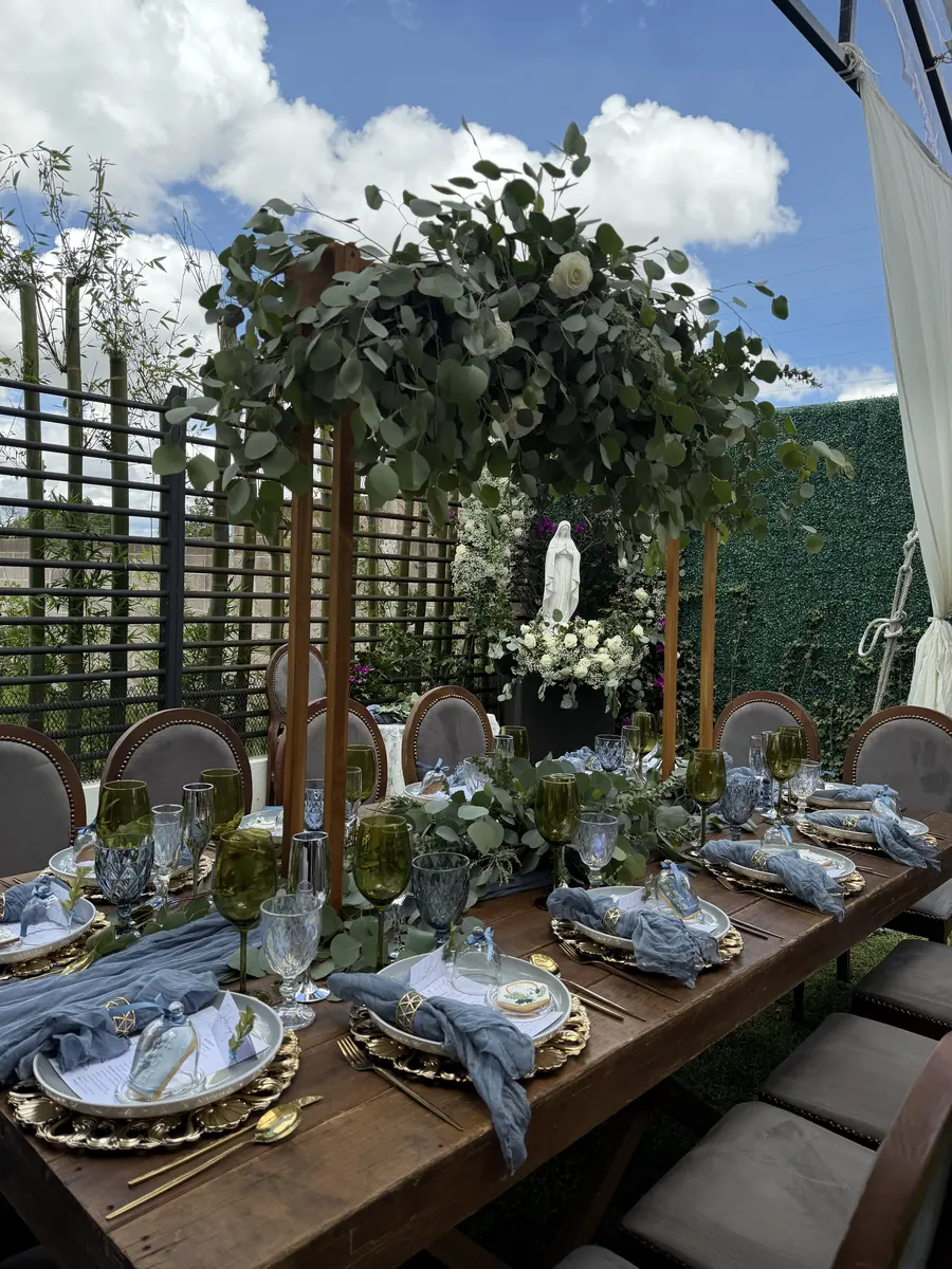 Mesa en jardín con arco de eucalipto y servilletas azules