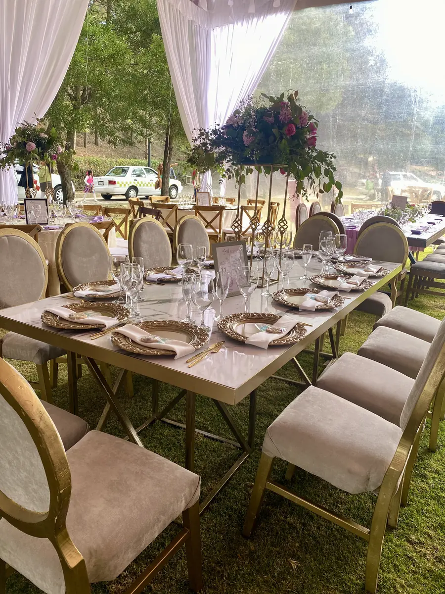 Mesa en jardín con sillas tapizadas y arreglos florales