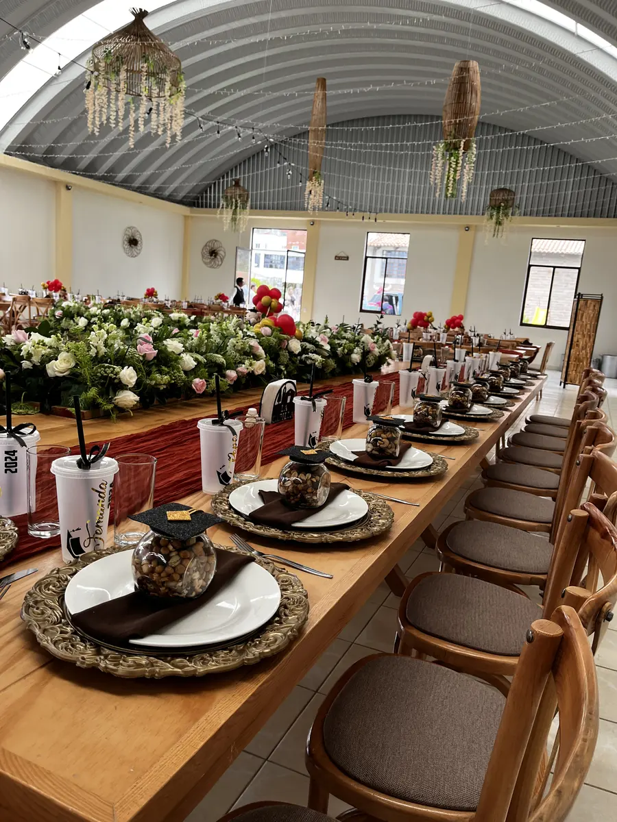Mesa imperial con platos base negros y flores rojas y blancas